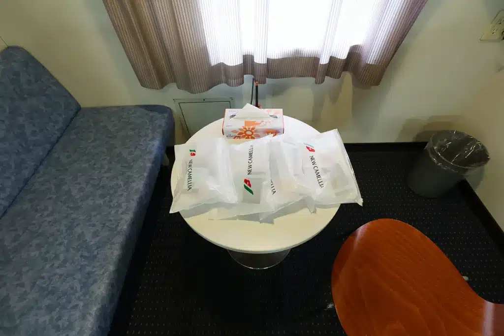Sofa and table in the New Camellia 1st Class Quad Room, amenity bag provided in upgraded rooms of 1st Class or higher