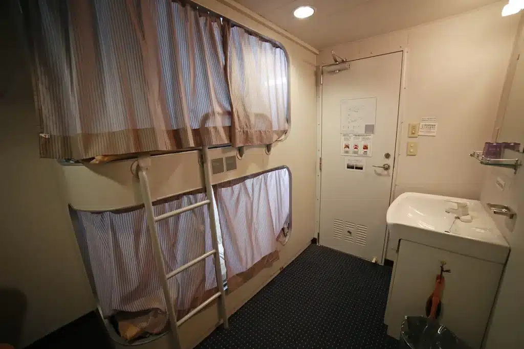 프라이버시 보호를 위해 개별 커튼이 설치된 뉴카멜리아호 1등 2인양실의 아늑한 야간 객실 분위기